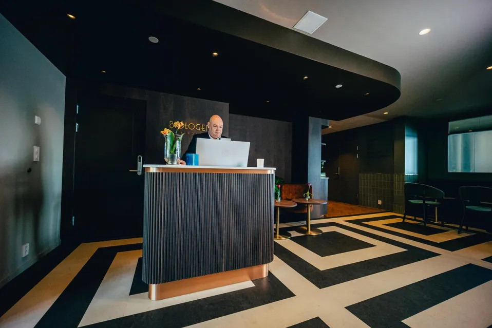 a man is sitting at a desk in front of a laptop computer .