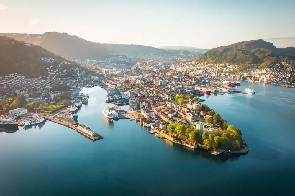 an aerial view of a city surrounded by water and mountains .
