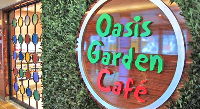 Oasis Garden Cafe er en restaurant med et grønt og rødt skilt.