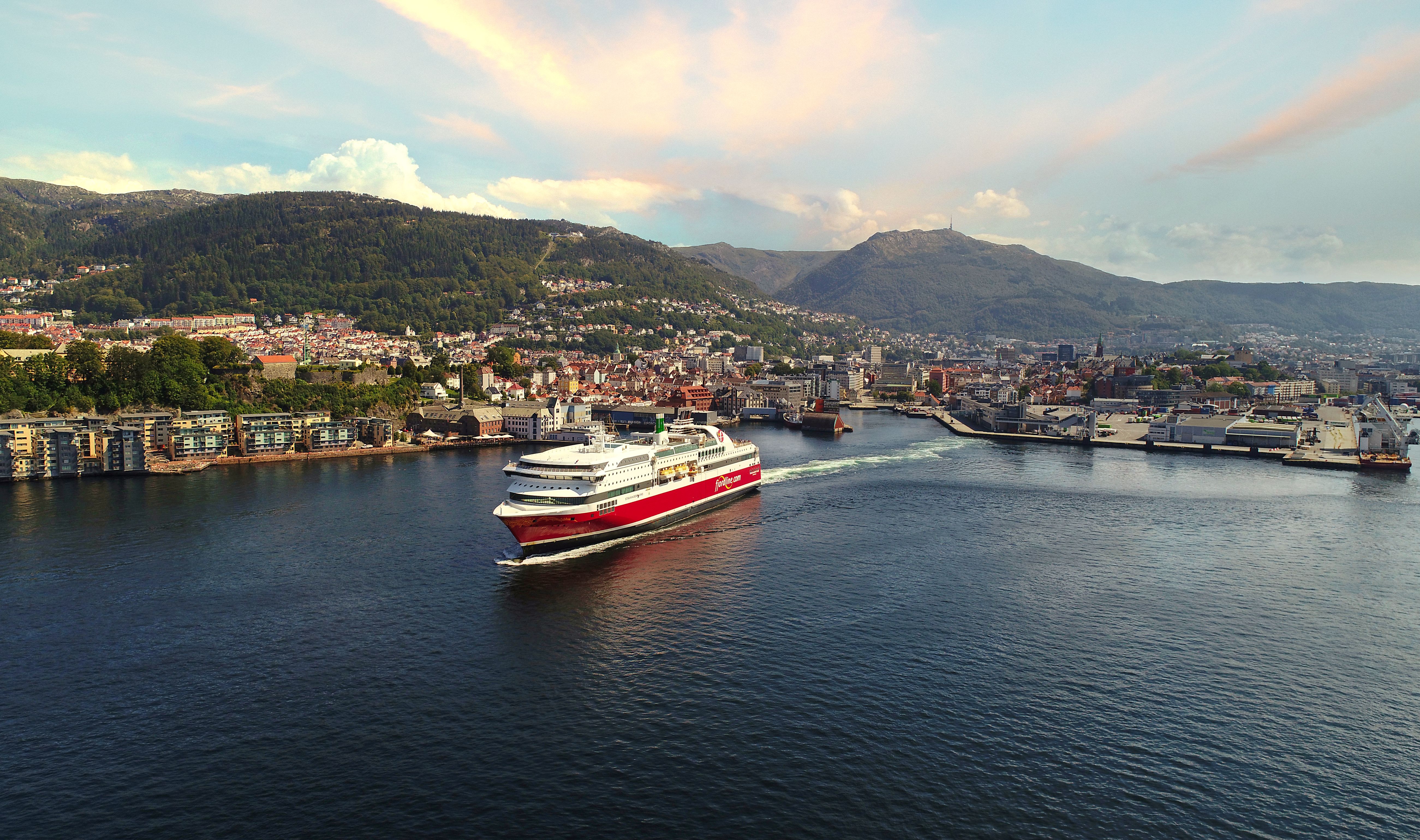 an aerial view of a cruise ship in the ocean near a city .