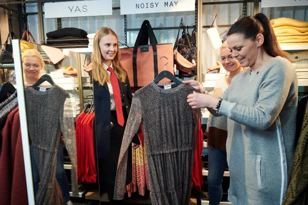 Dame holder kjole i butikk.