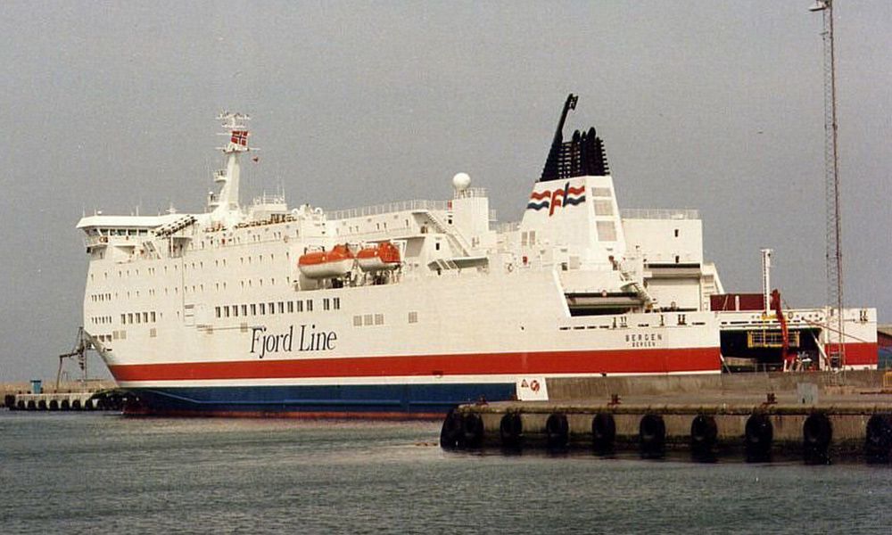 a large red , white and blue ship is docked in a harbor .