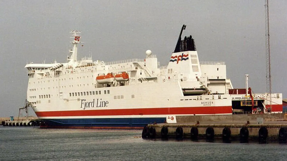 a large red , white and blue ship is docked in a harbor .