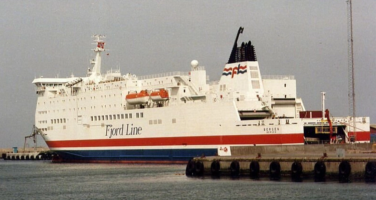 a large red , white and blue ship is docked in a harbor .