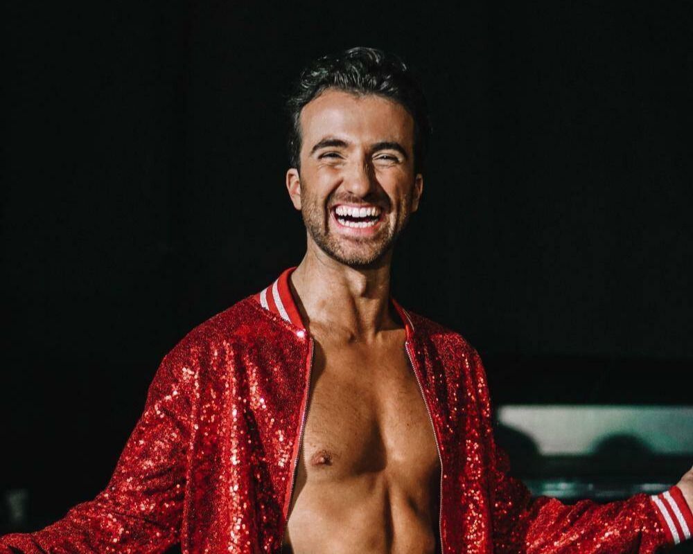 Mann som smiler med rød jakke.