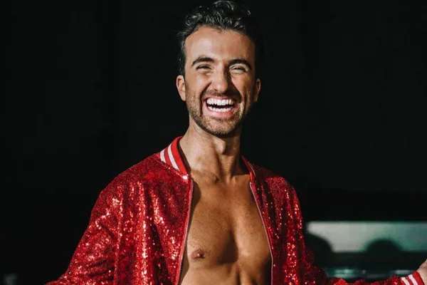 Mann som smiler med rød jakke.