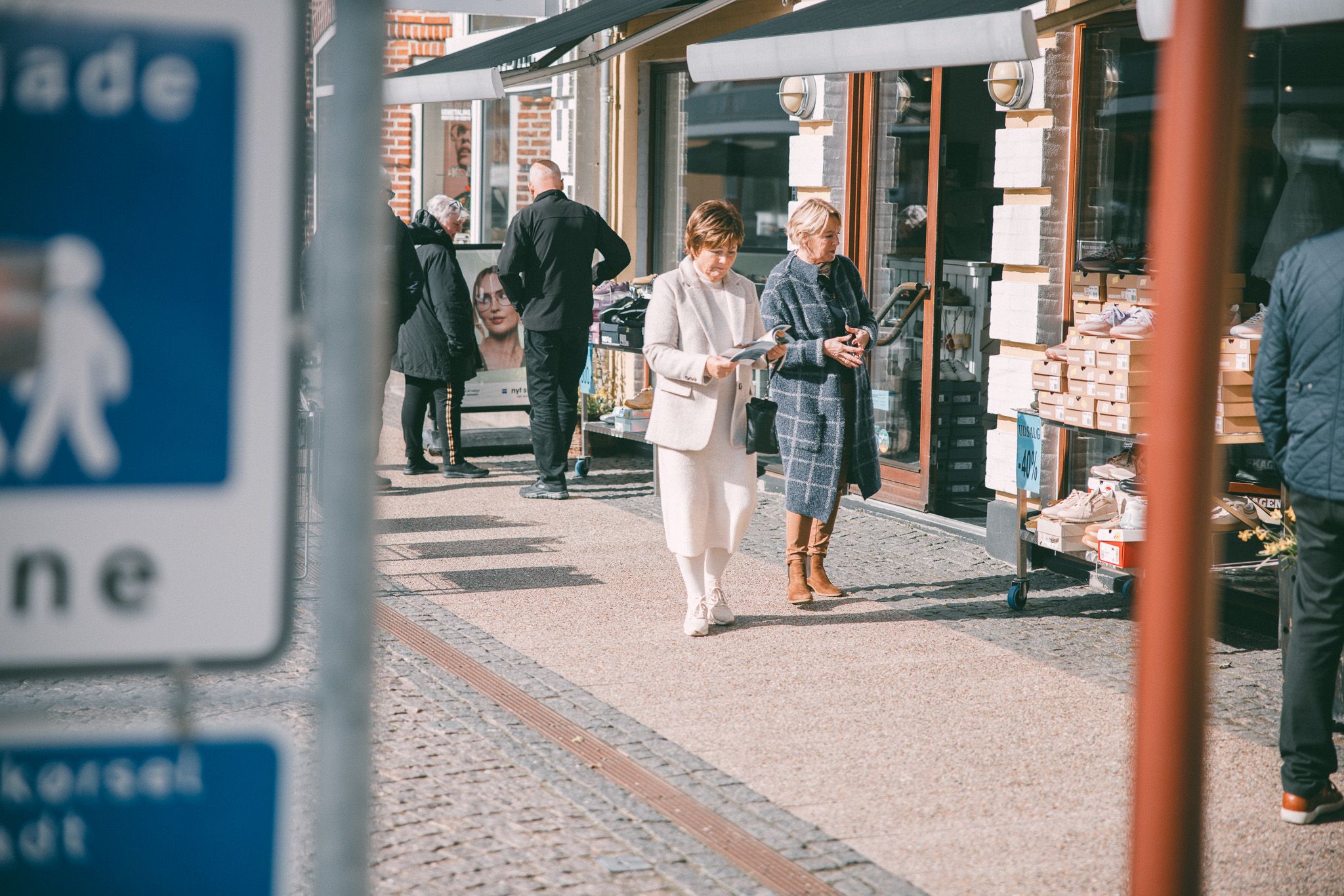To damer går i handlegate.