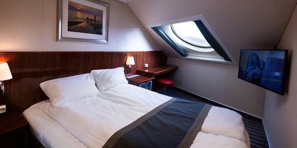 ein Hotelzimmer mit einem Bett, Schreibtisch und Fernseher.