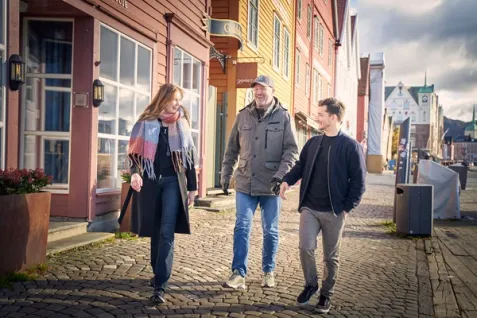 a group of people are walking down a cobblestone street .