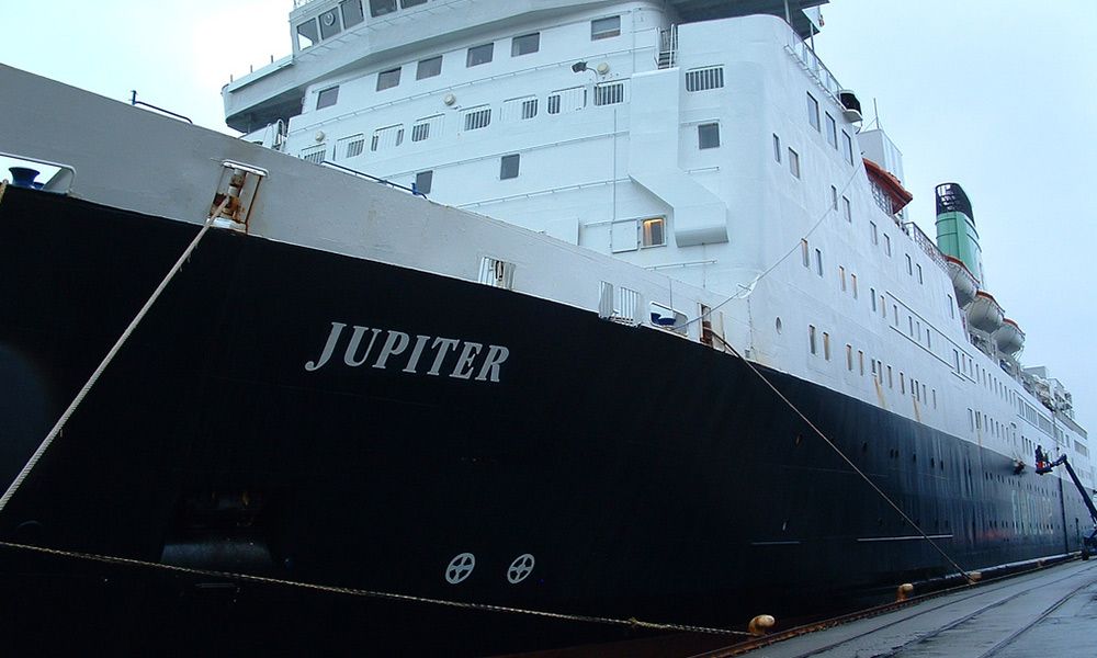 a large cruise ship is docked in a harbor .