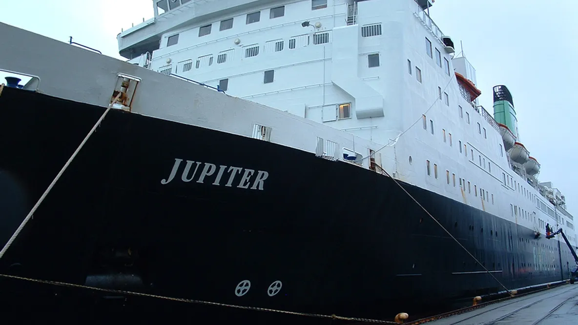 a large cruise ship is docked in a harbor .