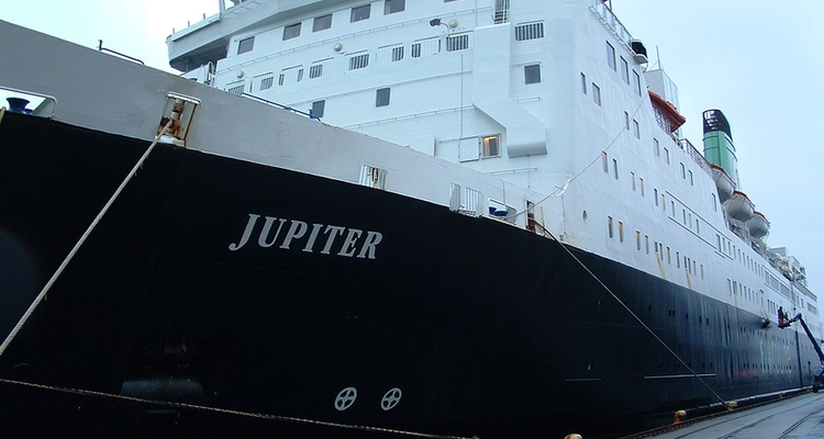 a large cruise ship is docked in a harbor .