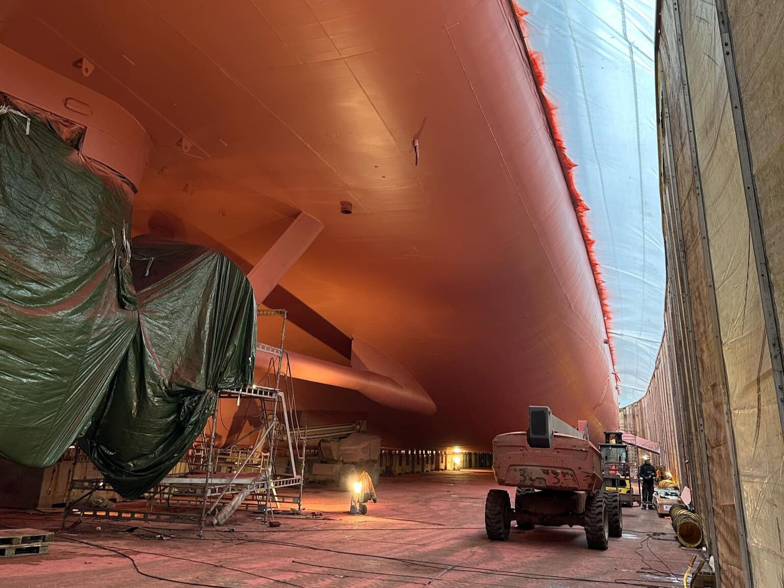 a large ship is being painted in a warehouse .