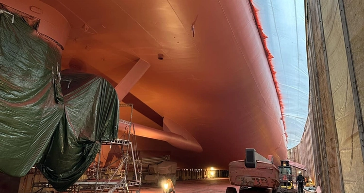 a large ship is being painted in a warehouse .