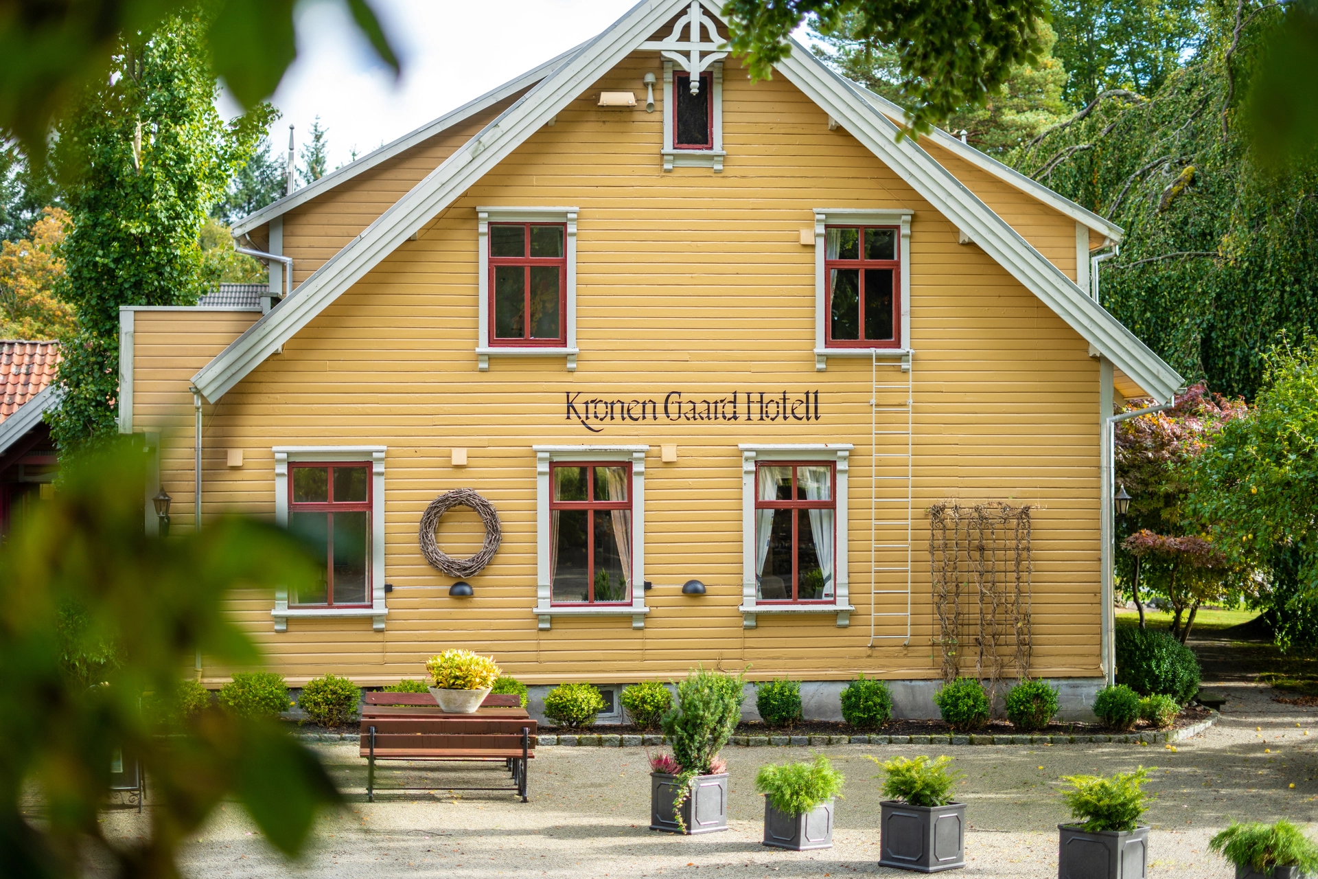 a yellow house with a lot of windows and a bench in front of it .