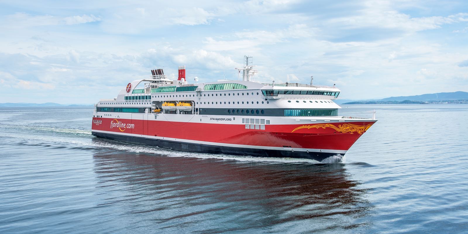 a large red and white cruise ship is floating on top of a body of water .