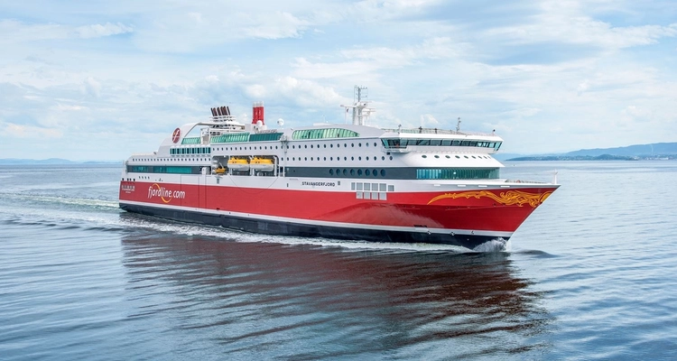 a large red and white cruise ship is floating on top of a body of water .
