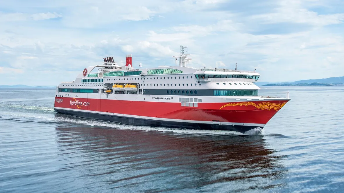 a large red and white cruise ship is floating on top of a body of water .