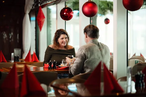 Par som sitter i julepyntet restaurant