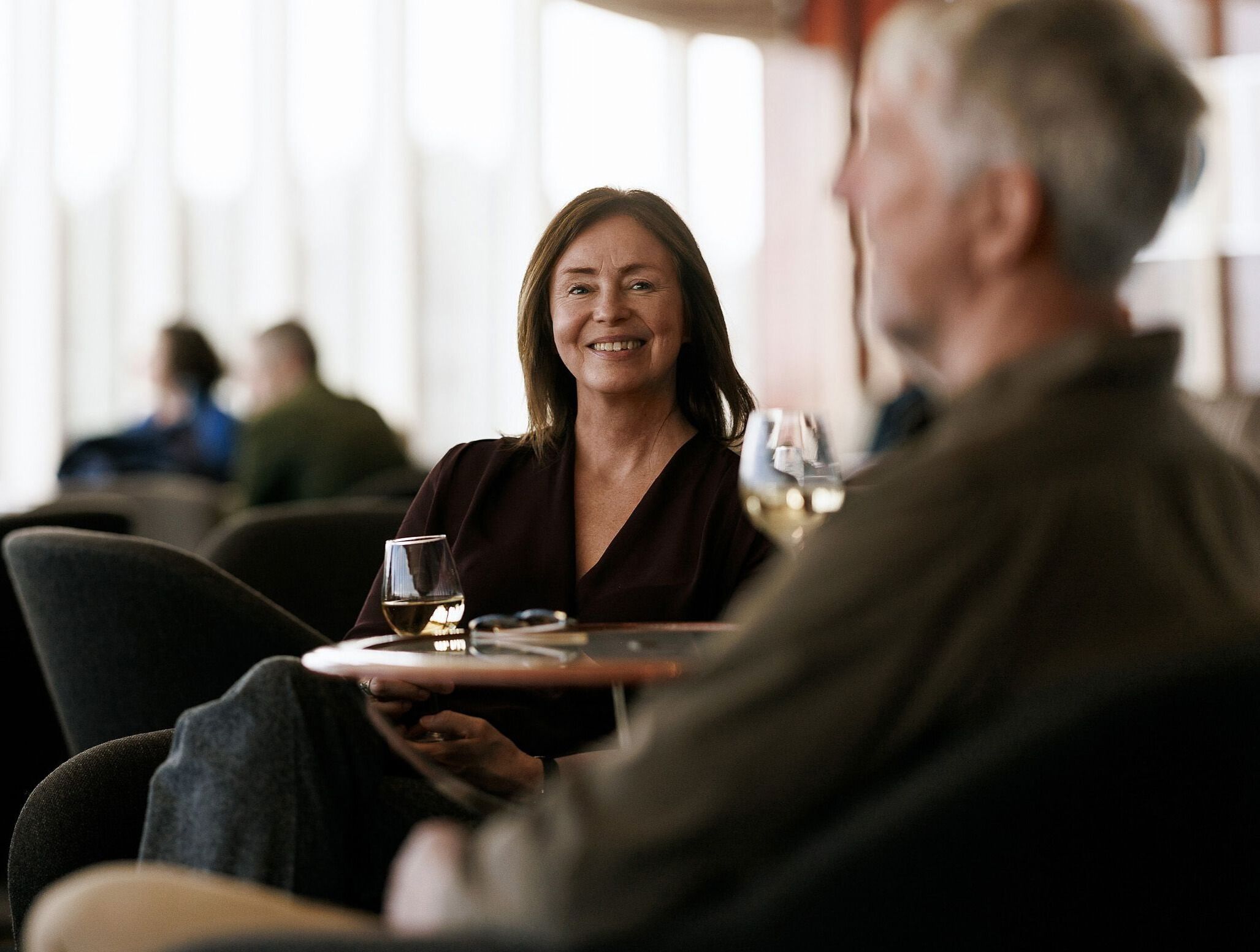 Dame sitter og smiler.