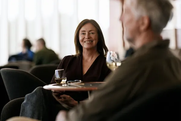 Dame sitter og smiler.