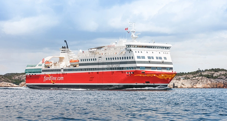 a large red and white cruise ship is floating on top of a body of water .