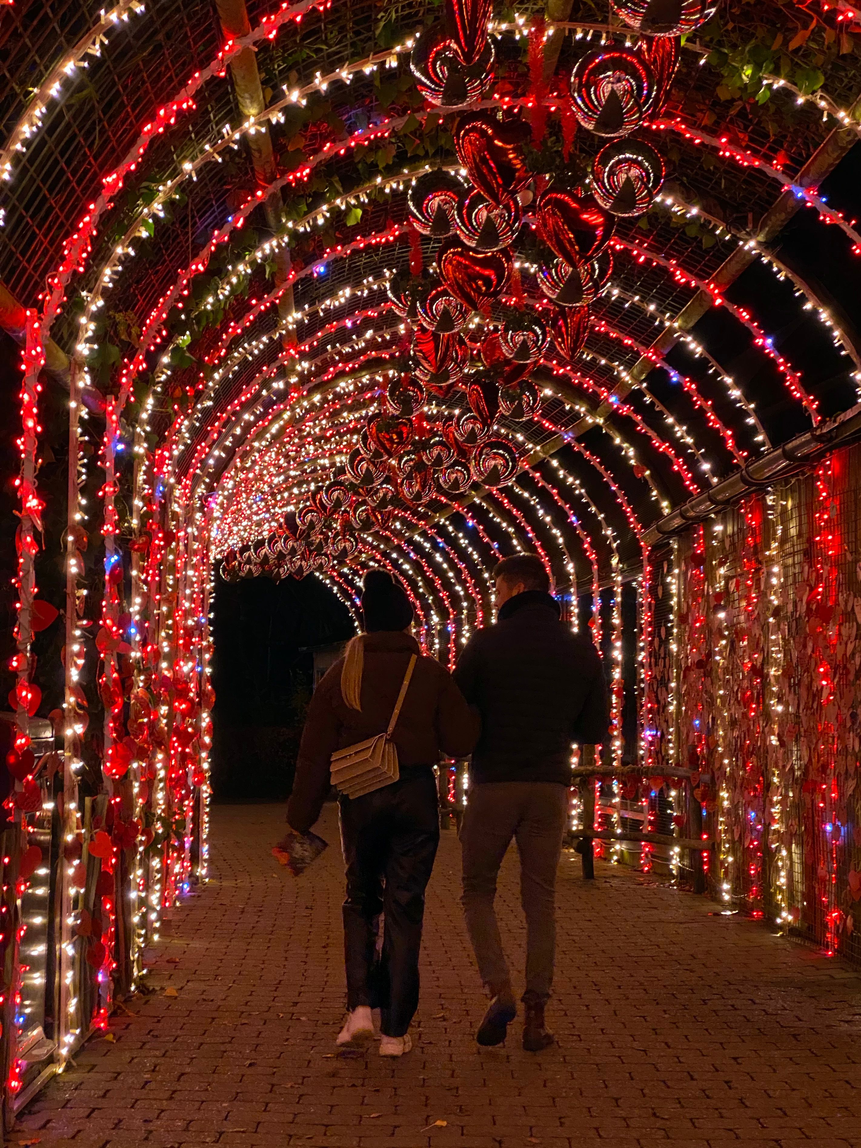 Par som går gjennom den opplyste hjertetunnelen. Foto. 