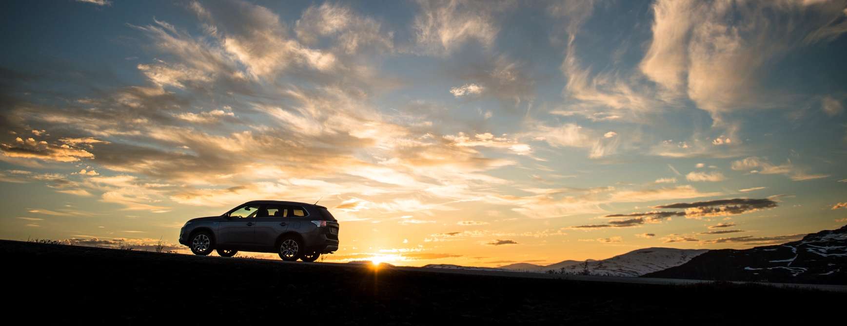 Auto auf einem Berg im Sonnenuntergang