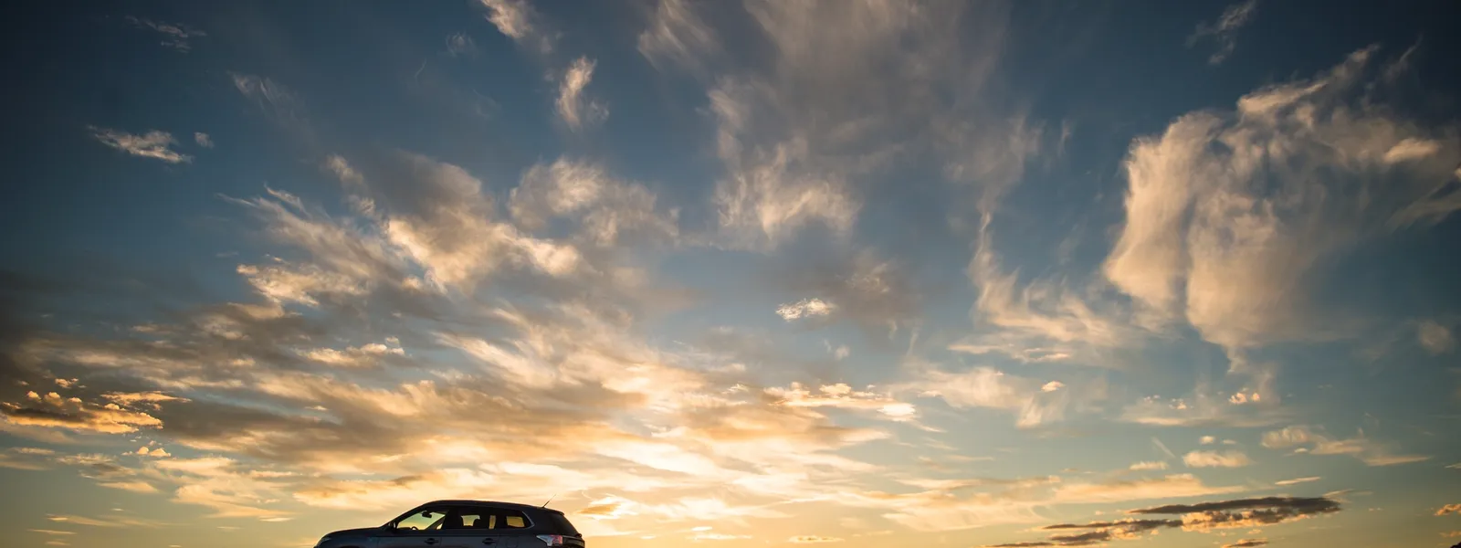 Bil på et bjerg i solnedgang