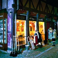 Jenter på brostein som kikker inn butikkvinduene til en gammel iskrembutikk