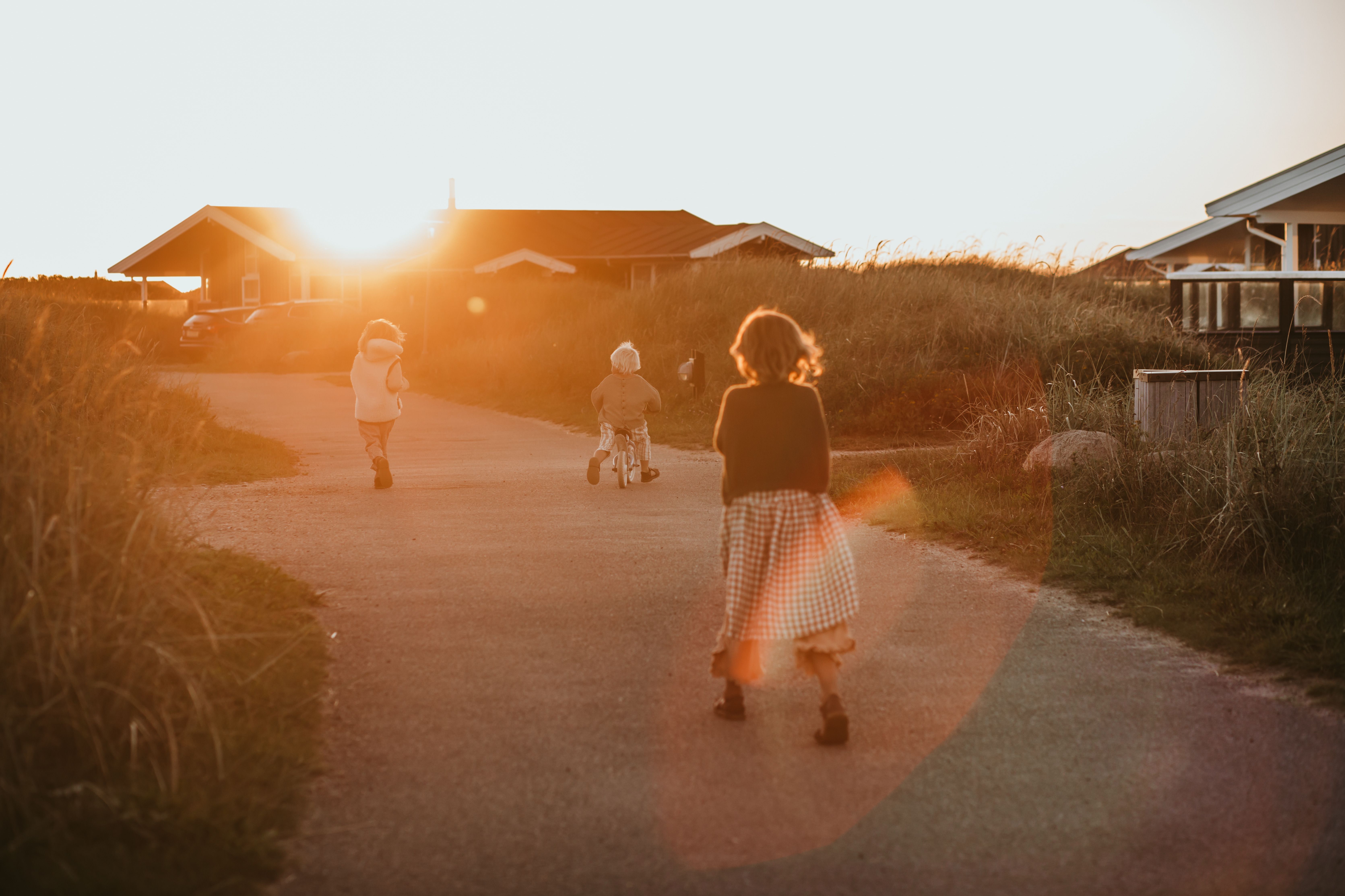 Barn som leker i de rolige gatene på feriesenteret. Foto. 