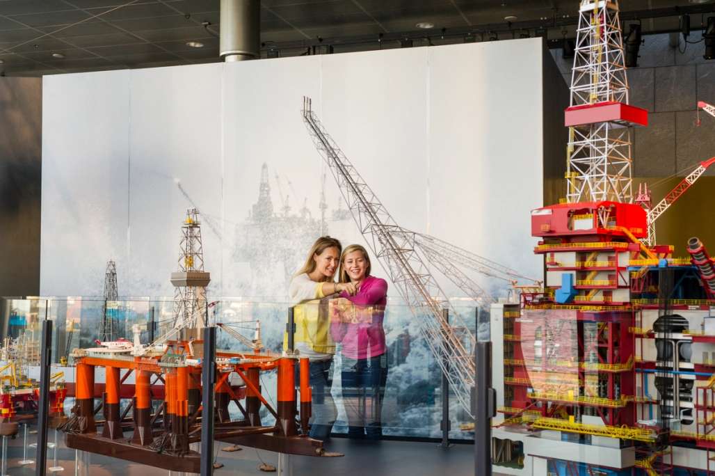 Eine Mutter und Tochter genießen die Ausstellung von Ölplattformen in einem Museum.