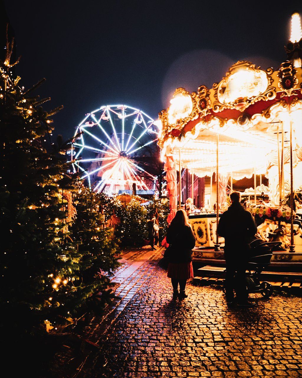 karuseller på gammeltorv opplyst av julelys. Foto. 