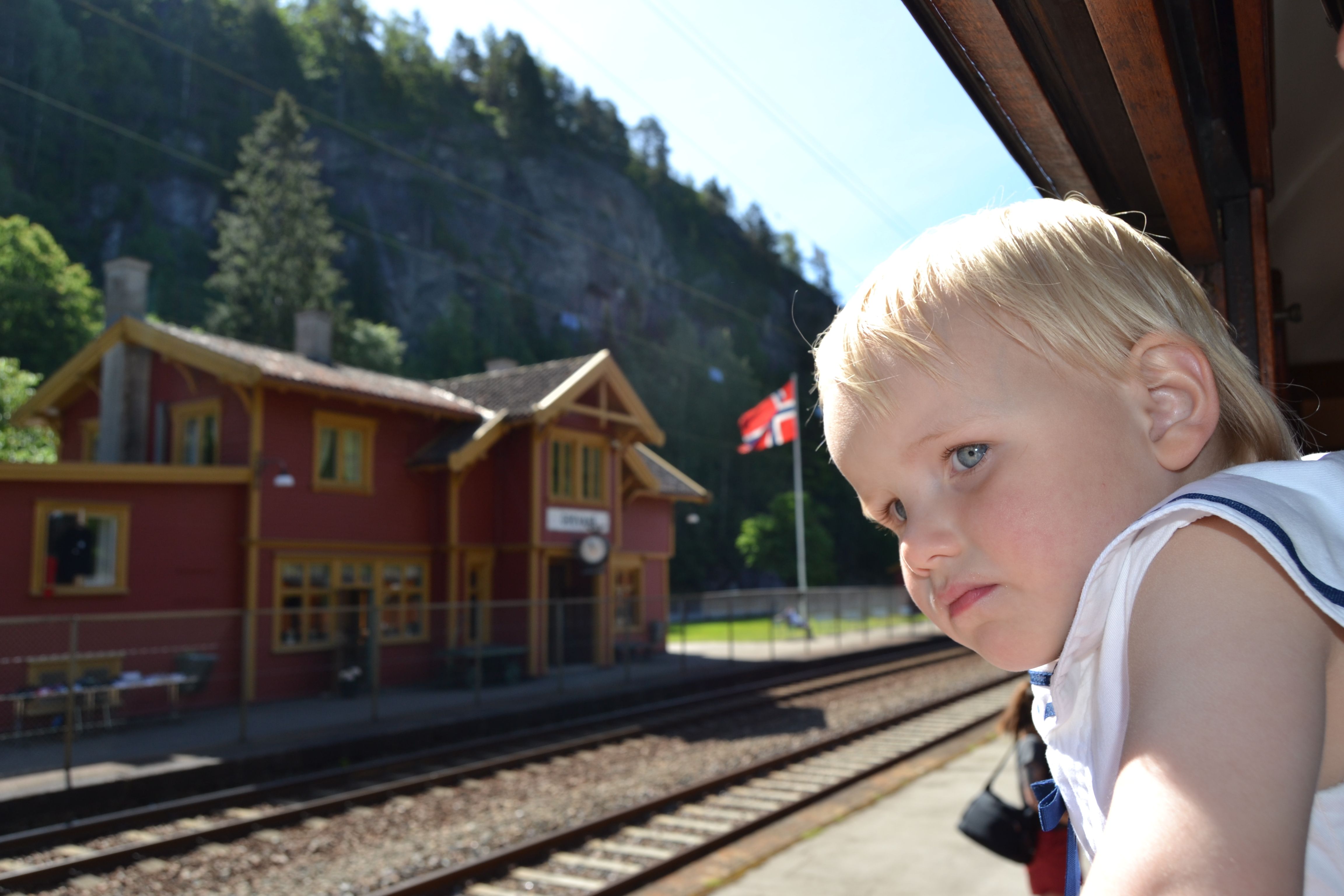 Little boy looks out of window on a train near a train station