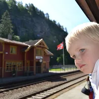 Little boy looks out of window on a train near a train station
