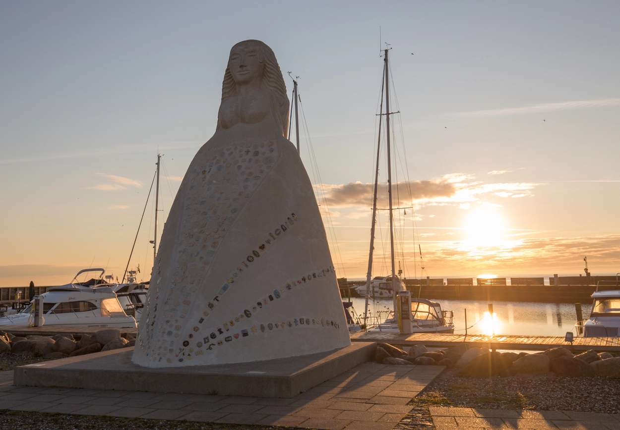 "Fruen fra havet" skuer utover havnen i solnedgang