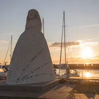 "Fruen fra havet" skuer utover havnen i solnedgang