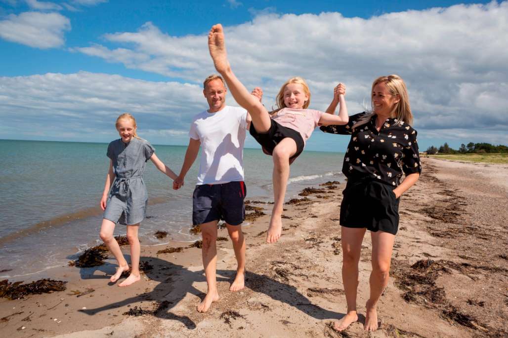 Familie hygger seg på en strand.