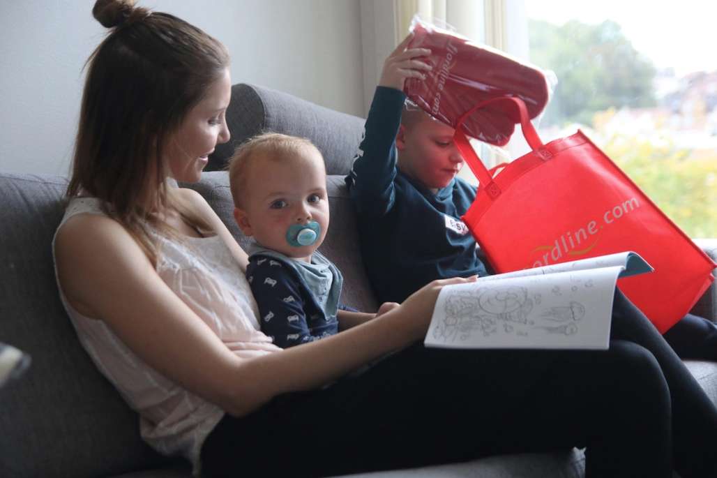 Mor og ta barn sitter i sofaen og ser på overraskelser.