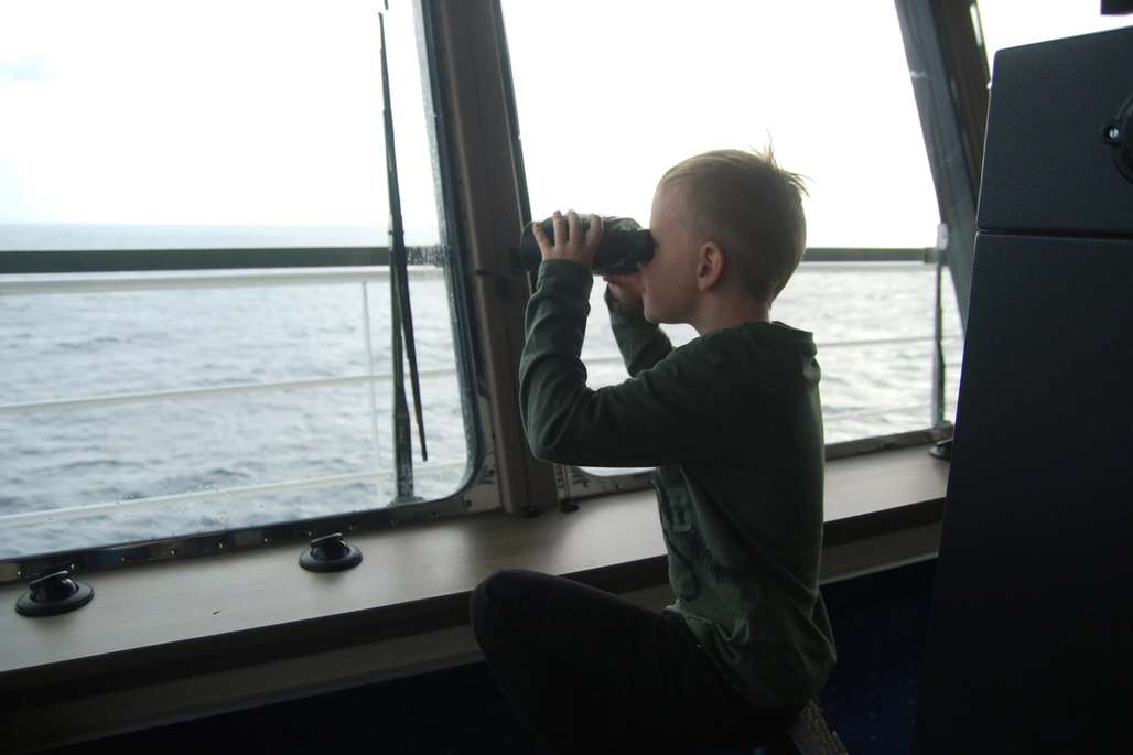 Gutt kikker i kikkert utover havet.