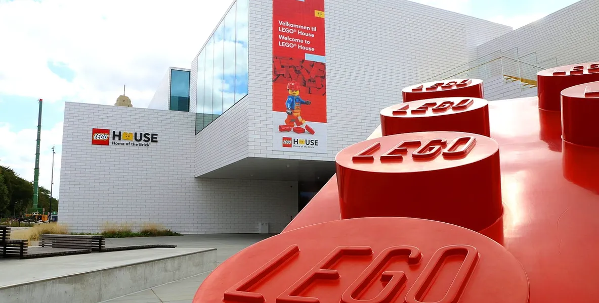 Utsiden av LEGO® House, med en stor rød LEGO®-klosse i forgrunnen.