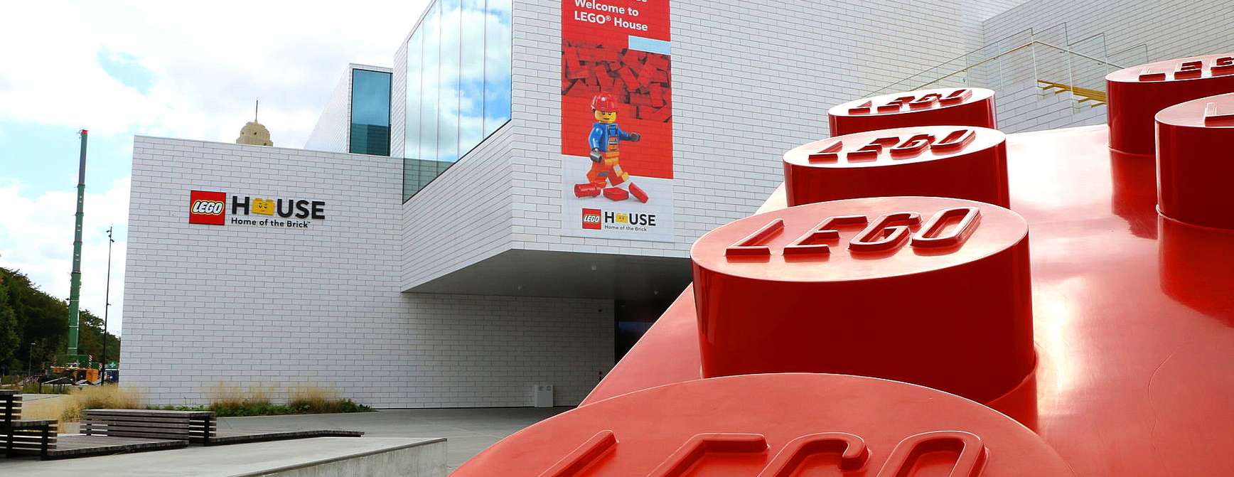 Utsiden av LEGO® House, med en stor rød LEGO®-klosse i forgrunnen.