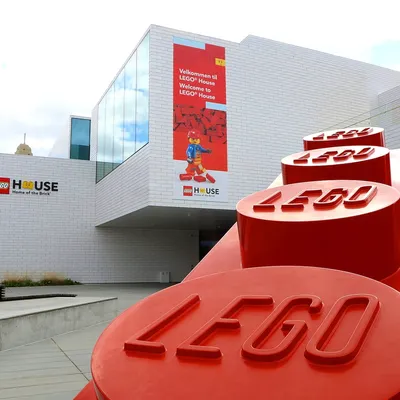 Utsiden av LEGO® House, med en stor rød LEGO®-klosse i forgrunnen.