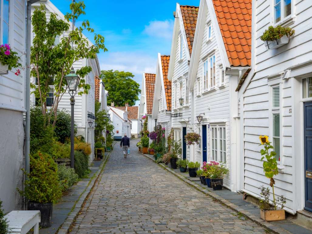 A cobbled street with white houses on either side.