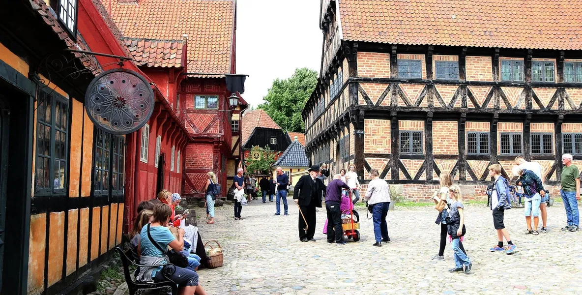Bilde av hest og kjerre på brostein blant gamle hus