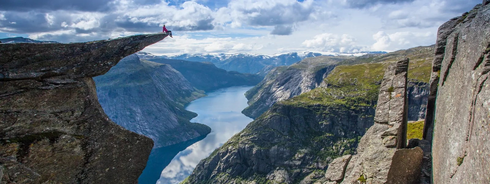 Person sidder på kanten af Trolltunga.