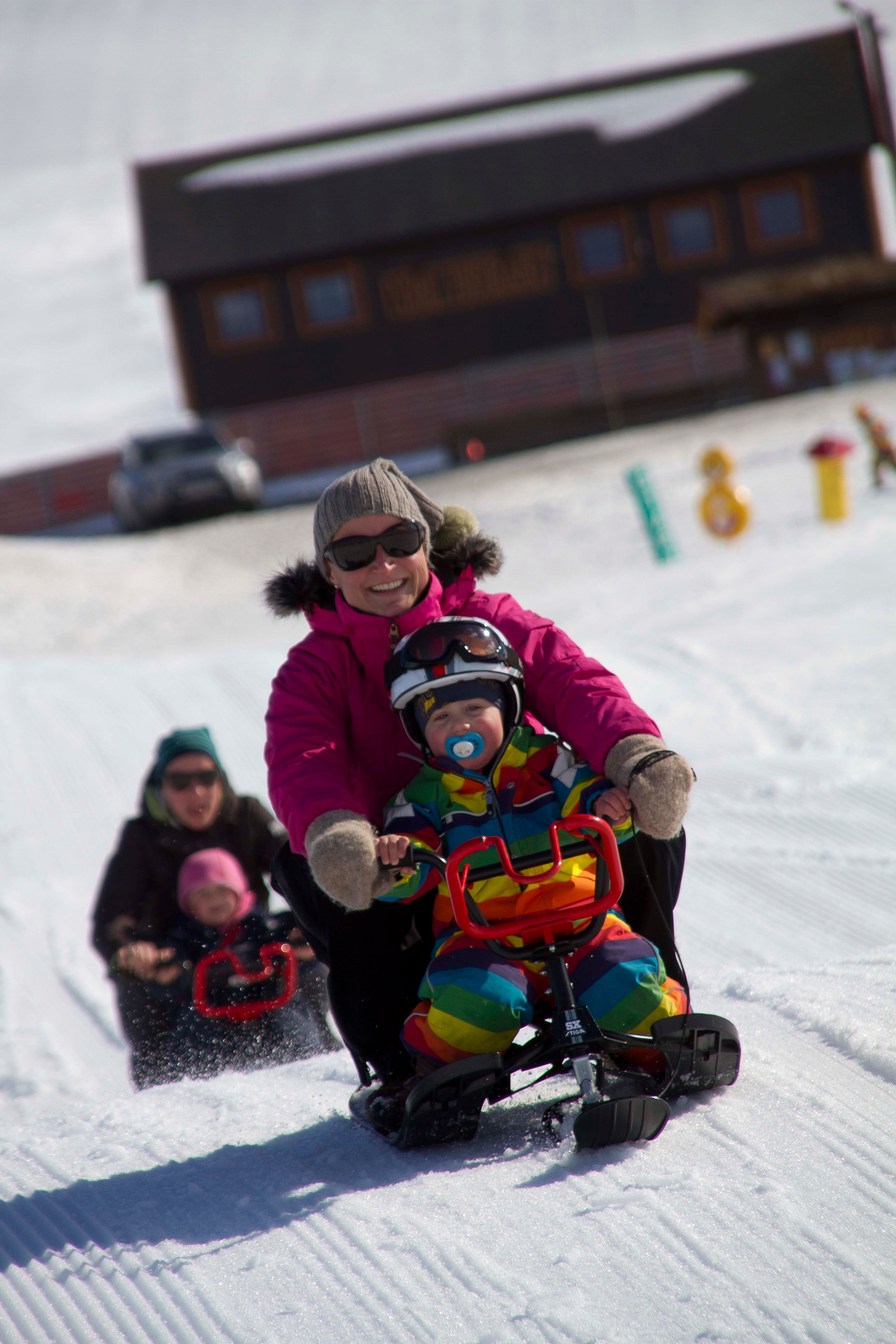 a group of people are sledding down a snowy hill