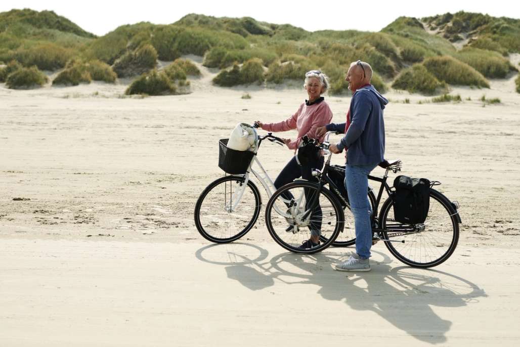 Par på sykkeltur på strand.