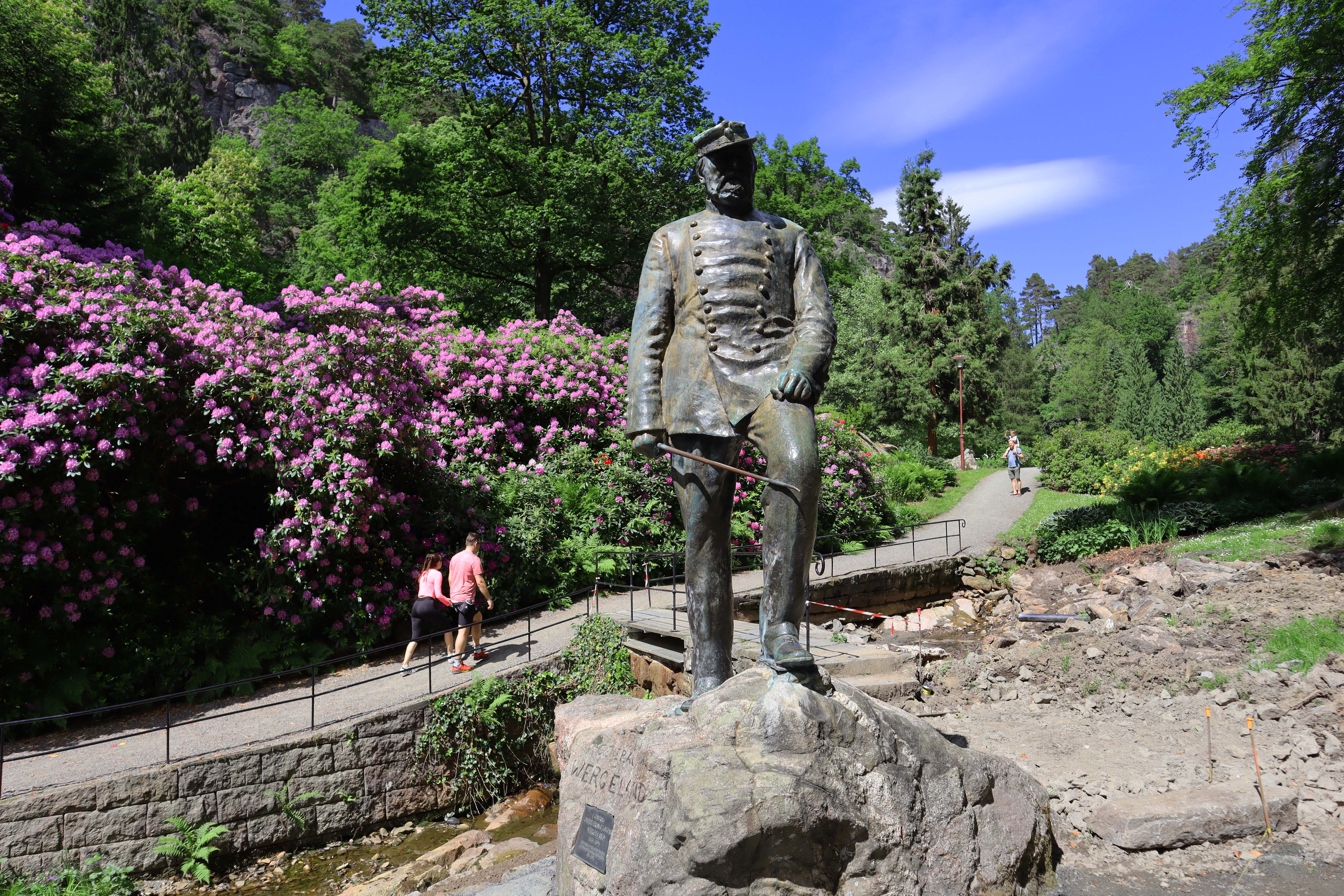 Statue with green surroundings and a pathway in the background