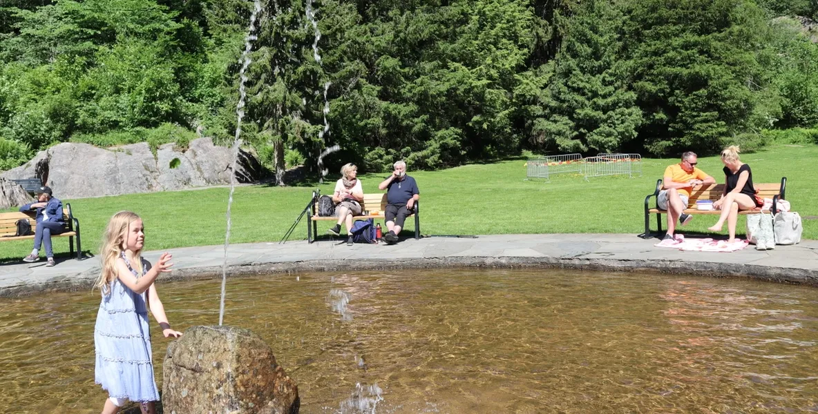 People are sitting on benches around a fountain